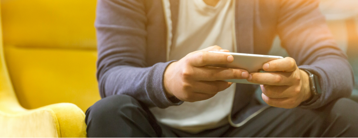 male sitting with phone in his hands