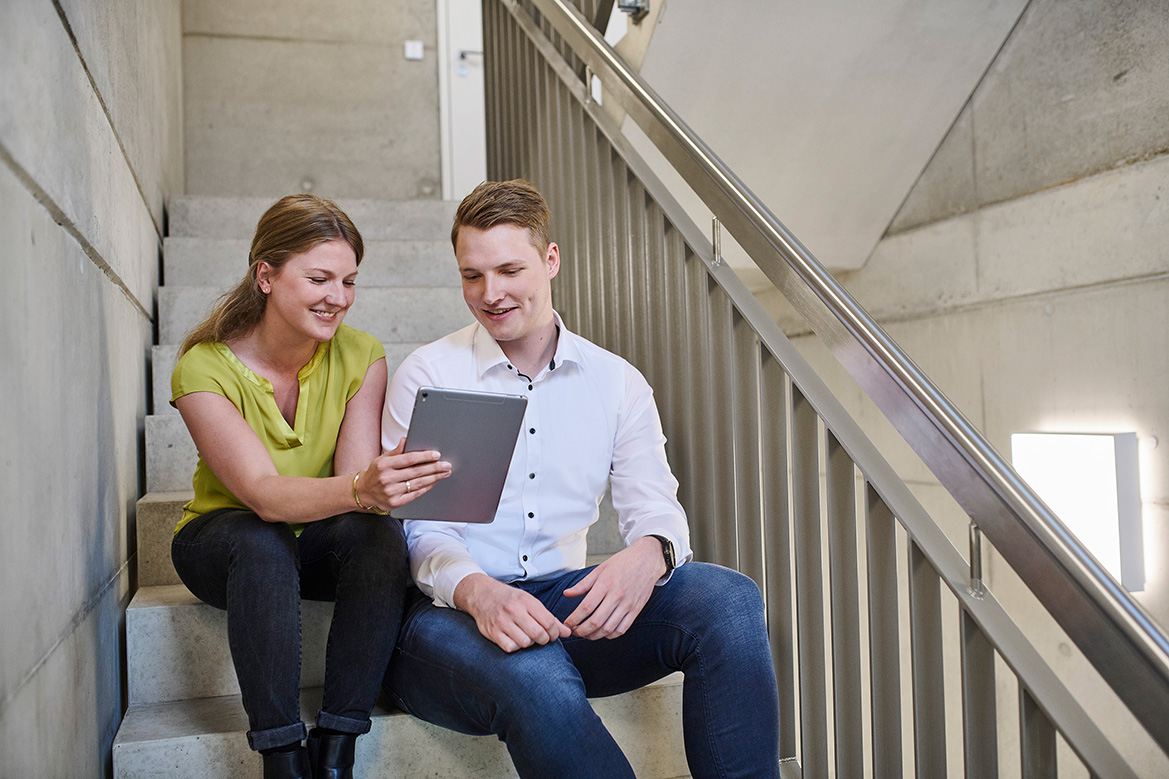 Two employees looking for digital signature on tablet