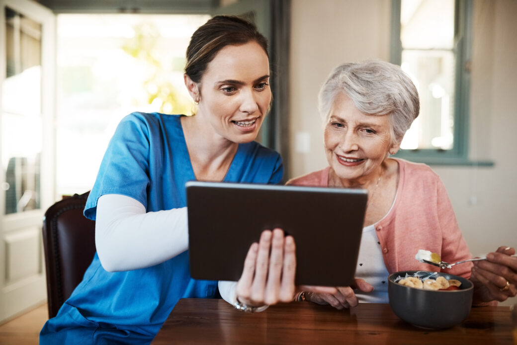 Shot of a young nurse and senior woman using a digital tablet